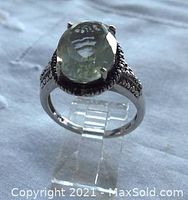 Front view of ring showing oval green amethyst and silver beaded frame