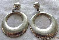Front view showing the circular silver hoop design and ball stud posts on a white cloth background.