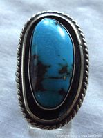 Front view of the ring showing oval turquoise stone and twisted rope silver bezel