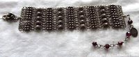 Full view of the vintage sterling silver multi-strand mesh bracelet laid flat, showing the mesh design and extension chain with garnet beads.