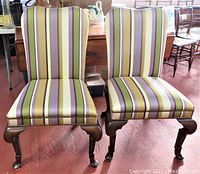 Front view of the two Queen Anne style chairs with striped upholstery showing the seat and backrest colors and wood legs.