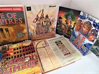 Nine vintage Age of Empires PC game manuals and strategy guides arranged for display, showing covers and partial interiors.