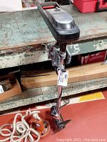 Vintage black STEALTH Power Plus 20 lbs trolling motor with wiring and clamps, propeller visible; on green workbench.