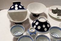 Blue and white Japanese rice bowls, China teacups, and artistic plates arranged together, showing their patterns and sizes.