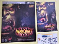 Close-up photo of the game's official strategy guide cover featuring an orc face artwork, with BradyGames and Blizzard logos.