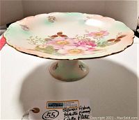 Full view of the Schumann Arzberg Wild Rose pedestal cake plate with floral and gold detailing on scalloped edges.