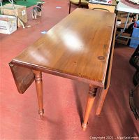 Side view of the pine wood drop leaf table showing one extended leaf and thick top