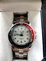 Front view of Swiss Activa watch showing white dial, luminous markers, and red-black bezel in original box.