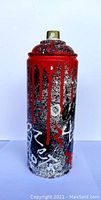 Spray paint can artwork showing front with red paint drips over black and white textured base with white graffiti-like markings.