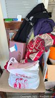 Full lot on a chair showing the winter coat, scarves and shoebox with bag in front