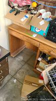 Wooden office desk with keyboard tray and storage cabinet, showing the drawer and empty leg space beneath the surface with items on top (contents not included).