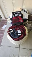 Photo of folded and rolled outdoor camping gear including a sleeping bag, thermal bags, and coolers.