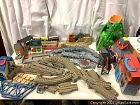 Overall view of multiple track pieces, bridges, and accessory buildings arranged on table.