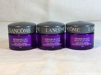 Three jars of Lancome Rénergie Lift Multi-Action cream side by side showing front labels and lids