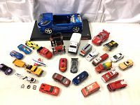 Overview photo of the entire lot showing 25 vintage die cast toy vehicles in various models and colors on a white background.
