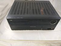 Top view of black Harman Kardon AVR 1700 stereo power amplifier receiver showing vented metal cover.