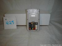 Back of Nintendo GameBoy with batteries exposed, showing missing battery door.