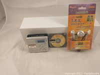 Sony MZ-R500 Mini Disk Walkman with mini disk and wireless earphones in packaging shown on flat surface.