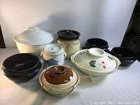 Group photo of 8 traditional Japanese cooking pots in various materials and designs on white background