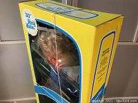 Front and side view of yellow and blue original box with clear window containing 30-inch Wendy Walker doll in navy outfit and scarf.