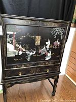 Front view of the Chinese lacquered cabinet showing detailed 3D inlay figures and brass hardware.