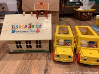 Fisher Price Play Family School toy with roof and playground bell tower next to two yellow buses with driver figures.