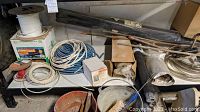 Shelving with various cables and wires coiled and on spools, miscellaneous hardware, tools, and boxes seen from above