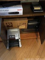 Sanyo DVD player box on shelf with Panasonic cassette recorder and Sony AG-300 box and device below