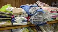 Assorted folded fabric remnants in many patterns and colors on a table