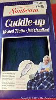 Photo of Sunbeam Cuddle-up heated throw original packaging, front view showing product name and image of woman using throw.