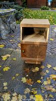 Solid wood bedside or occasional cabinet front view showing open top shelf and lower cabinet with door closed.