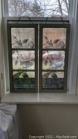 Front view showing both window panels hung side by side on a window sill, depicting their size and placement with floral printed film.