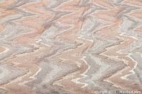 Close-up of upholstery fabric showing silver and salmon zigzag chevron pattern.