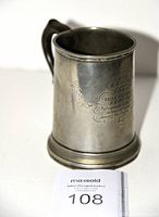 Three-quarter view of pewter mug showing overall form and patina