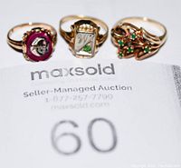 Three rings arranged on auction lot paper.