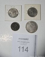 Photo showing 4 coins including Kennedy half dollars and old one-cent with seated Liberty half dollar replica