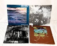 Photo showing four rock vinyl LP albums: Santana 'Moonflower', Aerosmith 'Night in the Ruts', Rolling Stones 'Goats Head Soup', and unidentified album with black and white photo cover.