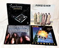 Four vinyl LP albums: Supertramp 'Crime of the Century,' Foreigner self-titled, Deep Purple 'Machine Head,' and Def Leppard 'Pyromania,' arranged flat on fabric background.