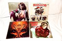 Four assorted rock LP records laid out side by side showing front covers: Peter Frampton, The Beatles '65, Triumph Never Surrender, Quiet Riot Metal Health