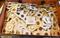 Photo showing a briefcase filled with numerous Canadian nickels in white cardboard holders.