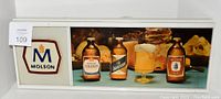 Front view of Molson beer lighted sign featuring vintage style bottle illustrations and beer glass image.