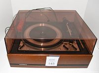Front view of Dual 1218 turntable in woodgrain plinth with tinted dust cover