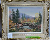 Framed landscape oil painting showing the full artwork and frame, including label with artist name.