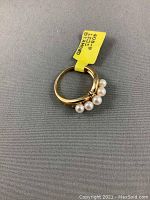 Ring on gray background with original yellow price tag attached