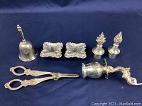 Photo showing full lot view with all silverware pieces arranged on dark fabric.