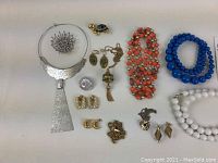 Full lot showing all 14 vintage costume jewelry pieces arranged on flat surface, including necklaces, brooch, earrings, pins, bracelets, and rings.