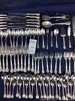 Full layout of flatware and serving utensils on dark background