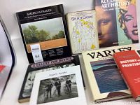 Seven art books positioned on table showing titles and covers including American Images, The Art Crowd, Variety, and others.