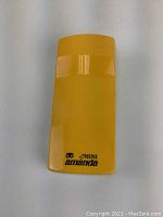 Front view of yellow plastic mini brush labeled 'Mini Amanda' showing its slim, rectangular shape.