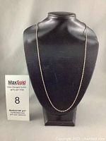 Full view of silver rope chain necklace on black display stand, showing the overall length and design.